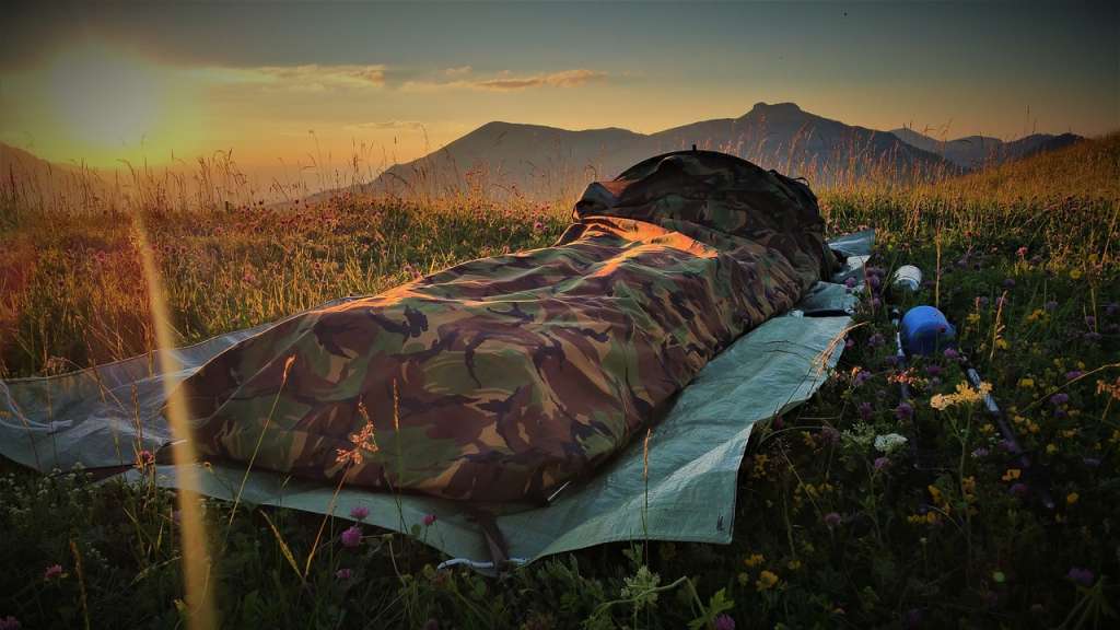 The image showcases an sleeping bag in nature. demonstrating bivouacking with minimal equipment specifically for a one-night overnight stay