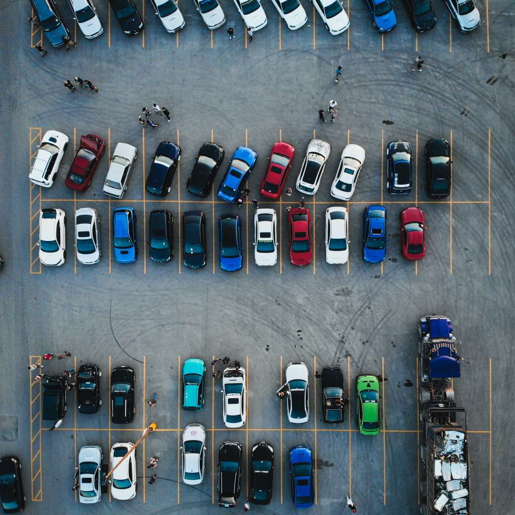 its a parking lot that displays cars from a helicopter view